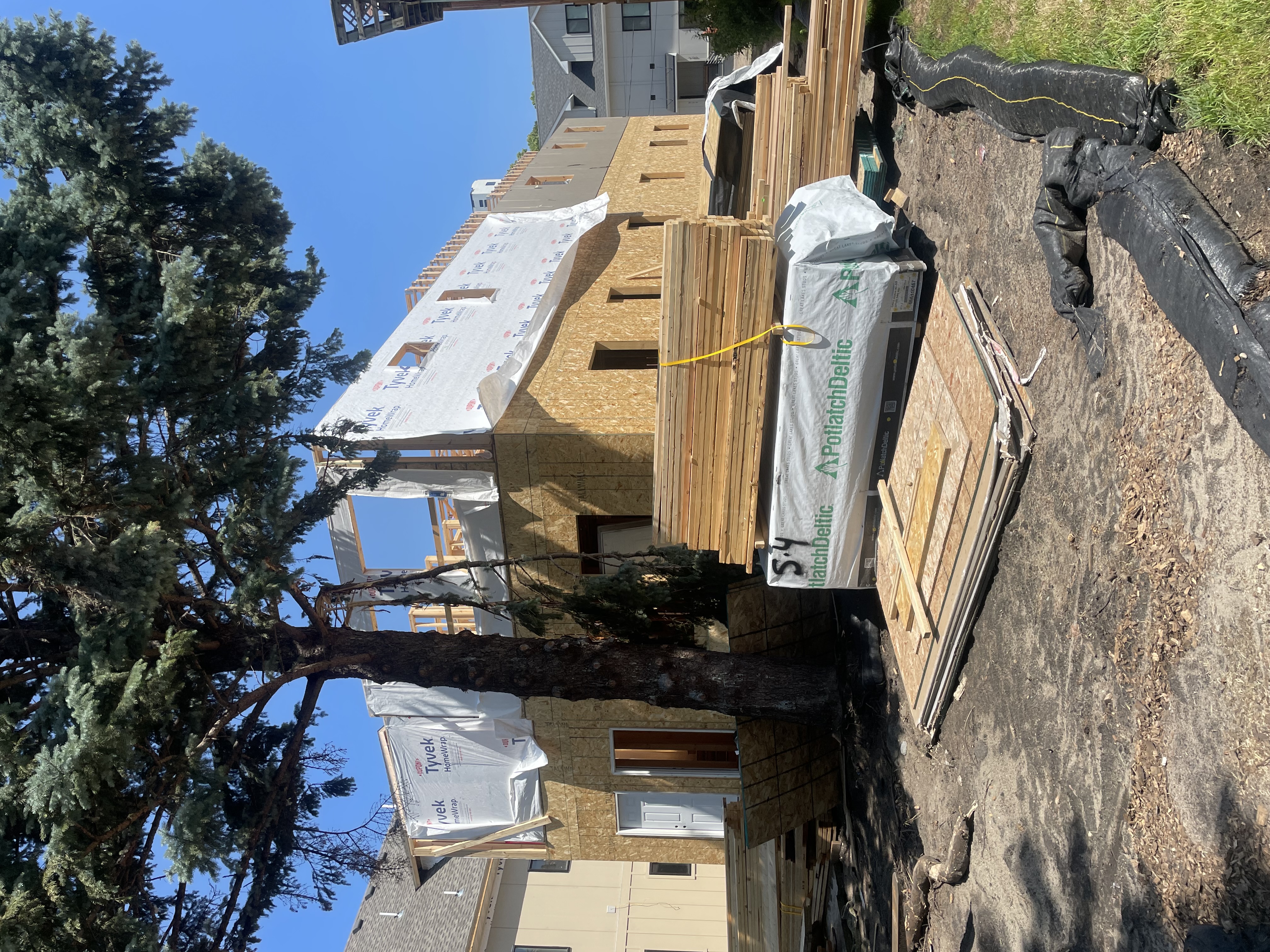 Framing lumber and structural sheathing panels stacked at a residential build site